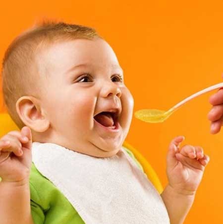 Happy baby being fed Suvarnaprashan - Ayurvedic immunity booster